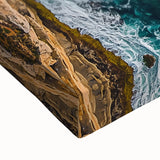 Close-up of a stretched canvas depicting a dramatic landscape of rugged cliffs under a vibrant sunset, showcasing rich colors and intricate textures, perfect for home décor.