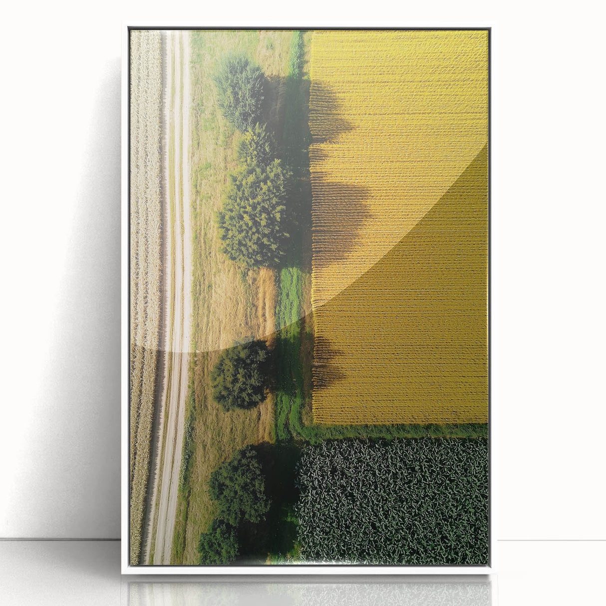 Framed acrylic landscape artwork showcasing a serene countryside scene with vibrant greenery and a clear blue sky, elegantly displayed in a white frame.