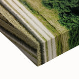 Close-up of a vibrant stretched canvas artwork depicting a serene countryside landscape, showcasing lush green fields, a clear blue sky, and rolling hills, perfect for home decor.