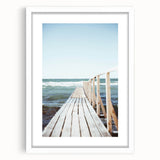 Abstract art print featuring swirls of blue and green, framed in white, ideal for dining room or bedroom decor.