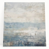 Abstract wall art canvas featuring vibrant, multicolored strokes in blue, orange, and yellow, leaning against a light gray wall, adding a modern touch to interior decor.