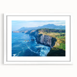 Framed landscape artwork depicting dramatic cliffs under a blue sky, featuring a white mat and elegant frame, perfect for enhancing home decor.