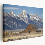 Stretched canvas artwork depicting a serene landscape featuring a rustic barn, vibrant greenery, and a clear blue sky, ideal for home decor.