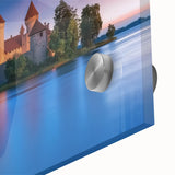 Close-up shot of an acrylic glass landscape artwork depicting a detailed castle surrounded by lush greenery, showcasing vibrant colors and intricate design elements.