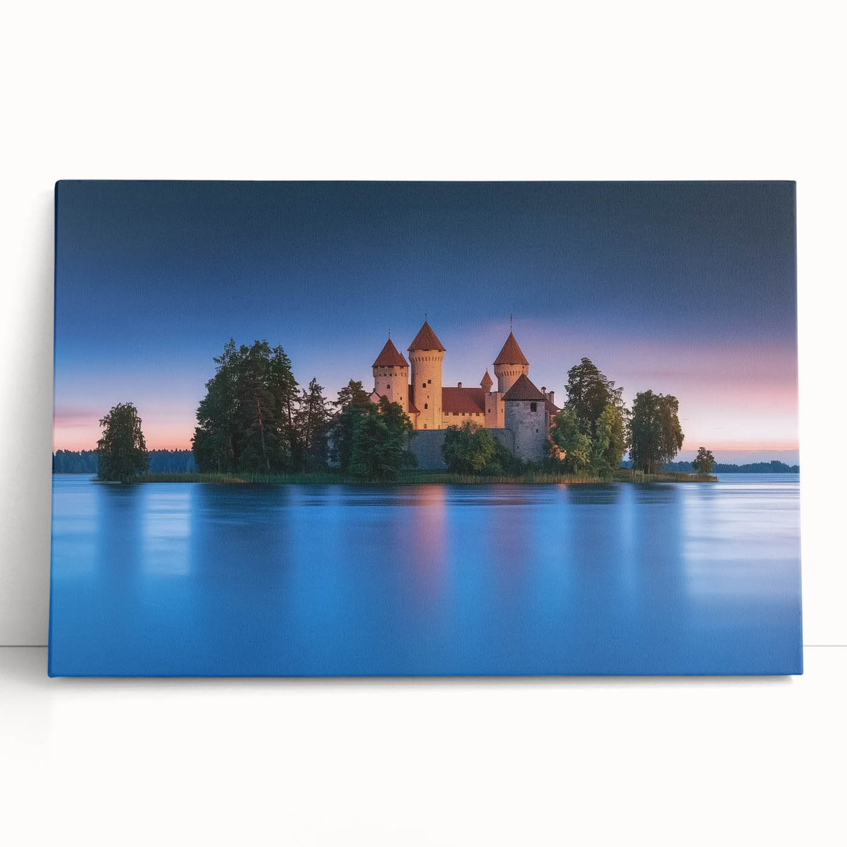 Stretched canvas artwork depicting a picturesque landscape with a medieval castle surrounded by lush greenery and a vibrant sunset sky, perfect for home decor.