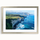Silver-framed artwork featuring a stunning landscape of cliffs, accented by a white mat, ideal for home decor, showcasing natural beauty and elegance.