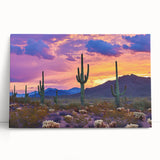 Stretched canvas artwork depicting a vibrant desert landscape with warm tones of orange and yellow, leaning against a wall, perfect for home decor.