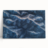 Desert landscape canvas art showcasing vibrant orange and yellow hues of a sunset over arid dunes, elegantly leaning against a wall for decorative display.