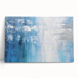Abstract wall art featuring vibrant strokes in shades of blue, orange, and yellow on stretched canvas, leaning against a neutral wall, adding a modern touch to interior decor.