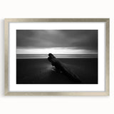 Framed landscape artwork showcasing serene beach scenery with soft blue skies and golden sands, accented by a sleek silver mat, ideal for coastal home decor.