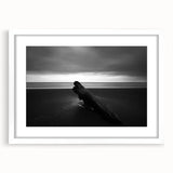 Framed landscape artwork depicting serene beach scenery with soft waves, a clear blue sky, and a white mat border, enhancing the coastal aesthetic.