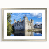 Silver-framed landscape artwork depicting a majestic castle surrounded by lush greenery, elegantly matted for a polished presentation, ideal for home decor.