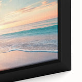 Close-up of a framed canvas depicting a serene beach landscape with vibrant sunset colors, capturing tranquil waves and soft sands, perfect for coastal decor.