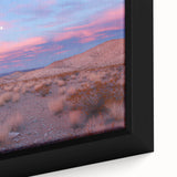 Close-up of a framed canvas artwork depicting a vibrant desert landscape with warm colors and textured details, ideal for enhancing home decor.