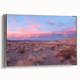 Framed canvas artwork depicting a serene desert landscape with warm tones of orange and gold, accented by a sleek silver frame, ideal for modern home decor.