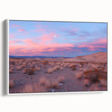 Framed canvas artwork depicting a serene desert landscape with warm colors, featuring cacti and mountains, displayed against a white wall for a modern aesthetic.