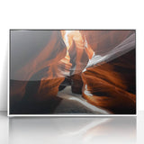 Framed acrylic landscape artwork depicting vibrant canyons in hues of orange and blue, displayed against a sleek white frame, ideal for modern home decor.