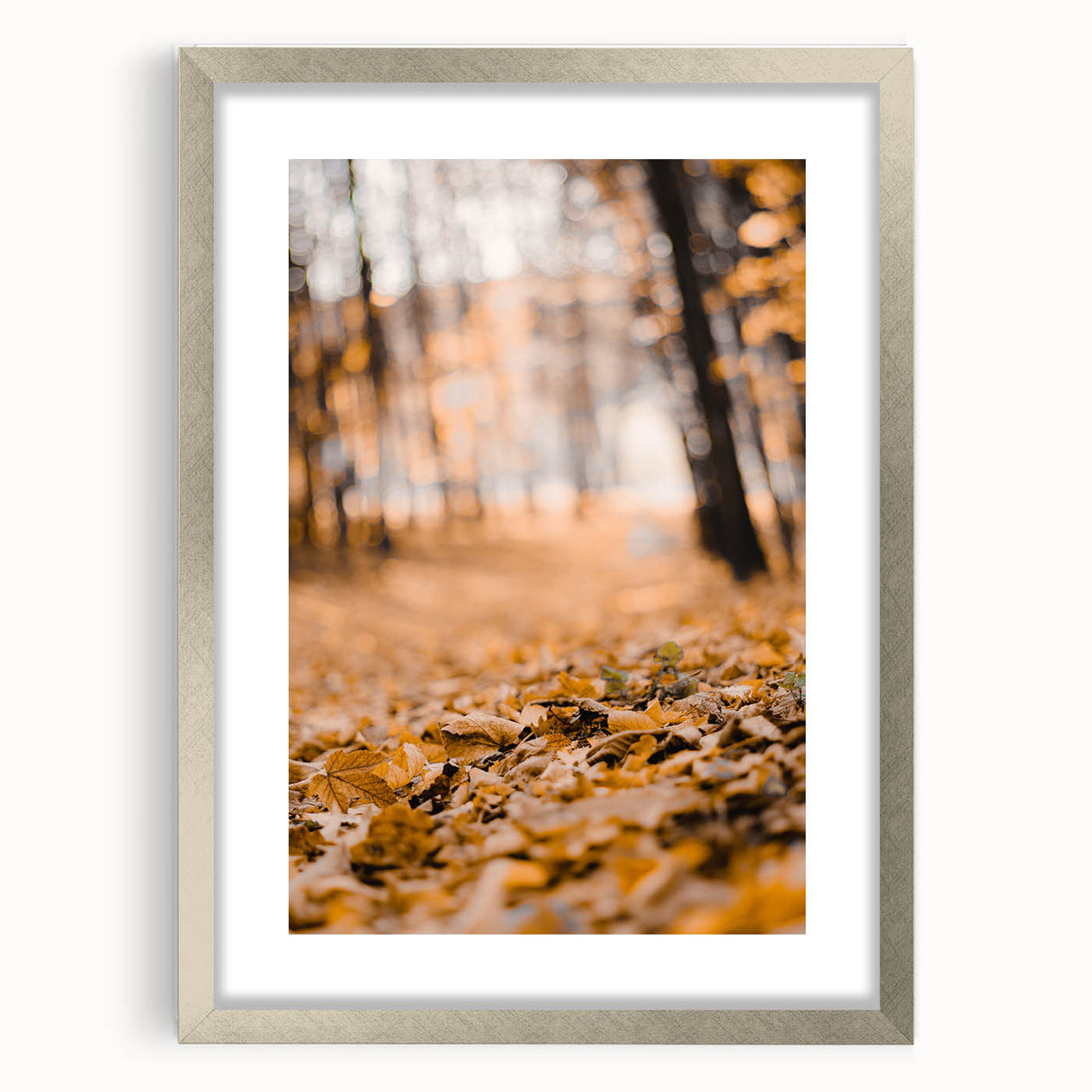 Textured abstract art print in warm autumn hues on a silver-framed canvas, suitable for bedroom decor.