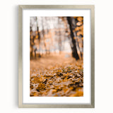 Textured abstract art print in warm autumn hues on a silver-framed canvas, suitable for bedroom decor.