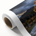Rolled canvas artwork depicting a vibrant landscape with an enchanting castle, showcasing rich colors and intricate details, packaged securely in a cardboard tube.