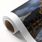 Rolled canvas artwork depicting a vibrant landscape with an enchanting castle, showcasing rich colors and intricate details, packaged securely in a cardboard tube.
