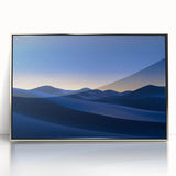 Framed acrylic artwork depicting a serene desert landscape with vibrant orange and yellow hues. The piece is elegantly displayed in a sleek silver frame, enhancing modern decor.