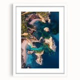White-framed landscape artwork showcasing dramatic cliffs against a serene blue sky, ideal for home decor. Perfect for adding a touch of nature to your space.