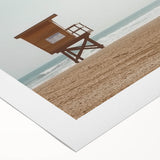 Rolled canvas artwork depicting a serene beach landscape at sunset, showcasing vibrant hues of orange and blue, perfect for coastal home decor.