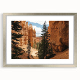 Silver-framed landscape artwork showcasing vibrant canyons, elegantly matted for a polished look, perfect for enhancing home decor with nature-inspired elegance.