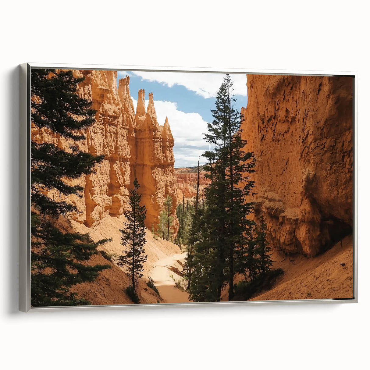 Framed canvas artwork showcasing a stunning landscape of canyons in vibrant colors, elegantly mounted with a sleek silver frame, perfect for home decor.