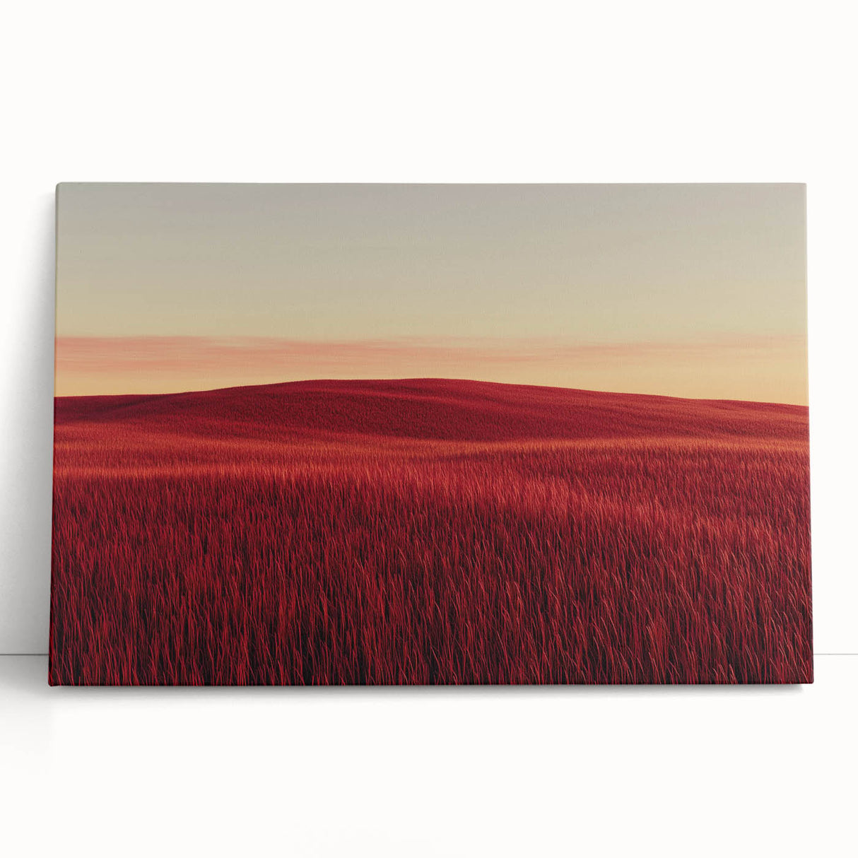 Stretched canvas artwork depicting a serene countryside landscape with lush green fields and a vibrant blue sky, leaning against a rustic wall, perfect for home decor.