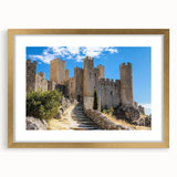 Elegant gold-framed landscape artwork showcasing a majestic castle surrounded by lush greenery, presented with a mat for an enhanced aesthetic appeal. Ideal for home decor.