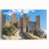 Stretched canvas artwork depicting a vibrant landscape with a majestic castle framed by lush greenery and a clear blue sky, perfect for home decor.