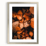Textured abstract art print featuring warm autumn tones on a silver-framed canvas, ideal for bedroom decor.