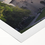 Rolled canvas print showcasing a stunning landscape with a majestic castle surrounded by vibrant greenery and a serene sky, elegantly packaged for protection.