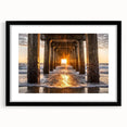 Black-framed landscape artwork showcasing serene beach scenery under a vibrant sunset, complete with a white mat for a polished look, ideal for home decor.