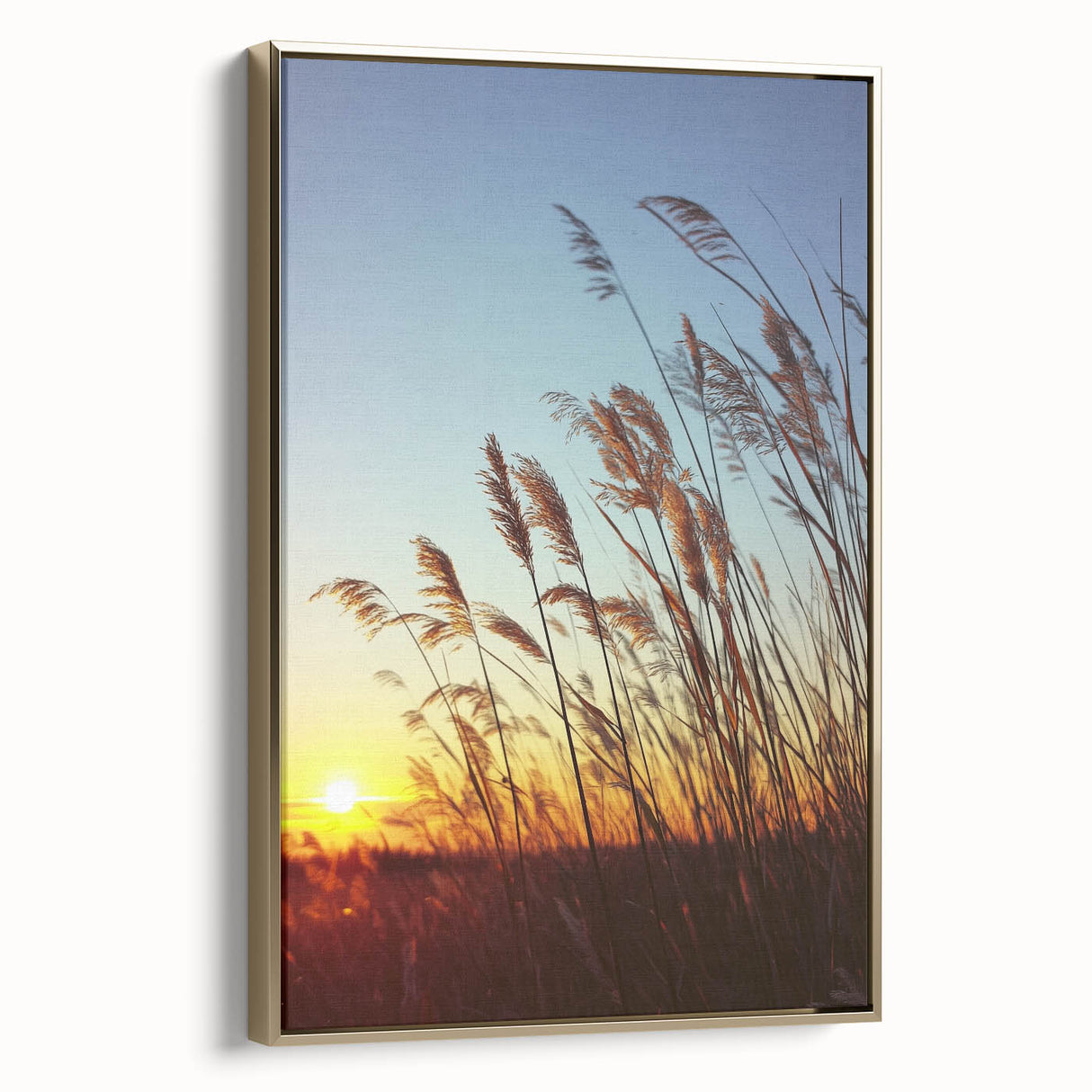 Framed canvas landscape artwork depicting a serene countryside scene, featuring vibrant green fields and a clear blue sky, with an elegant gold frame enhancing its aesthetic appeal.