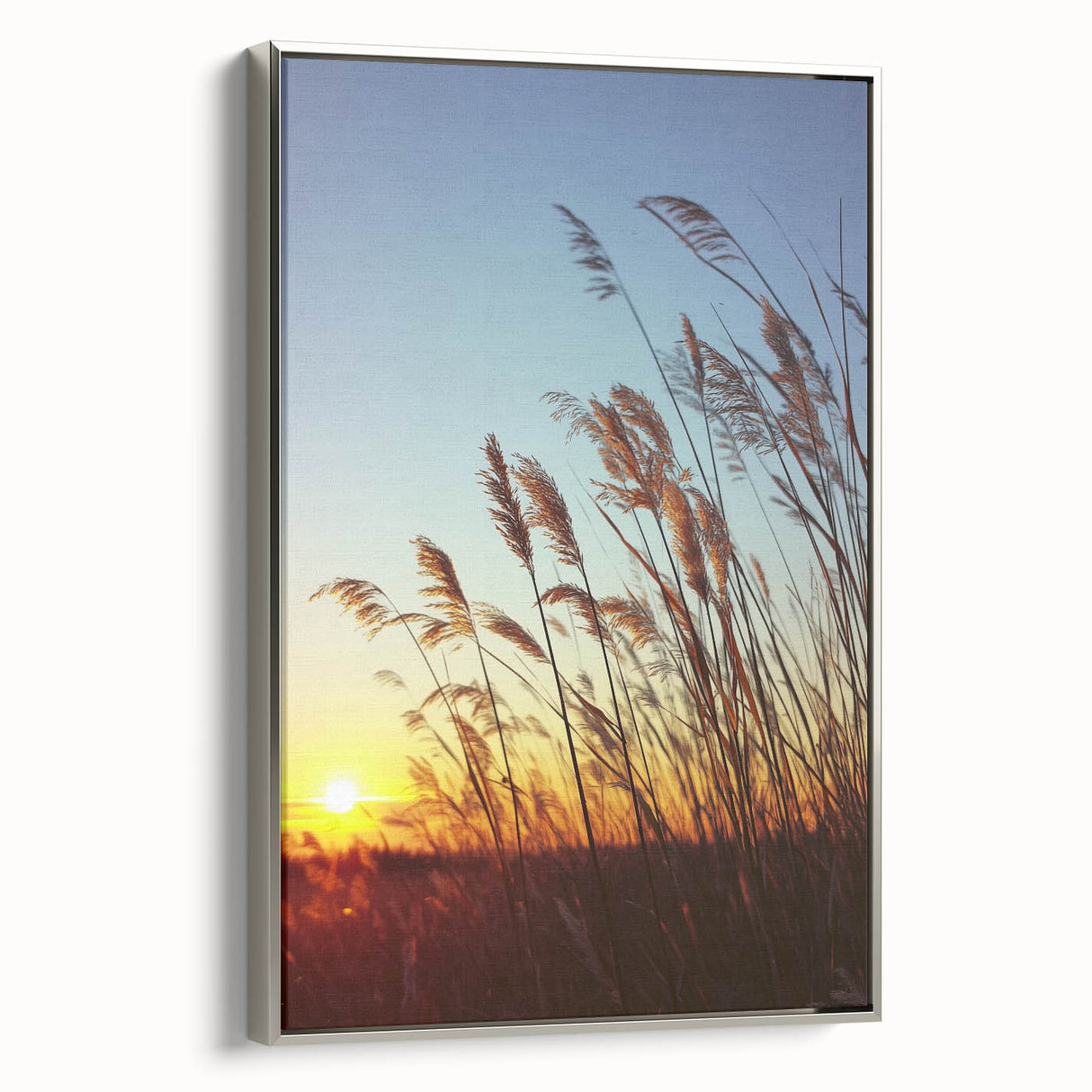 Framed canvas art showcasing a serene countryside landscape with vibrant green fields and a clear blue sky, elegantly bordered in silver, perfect for home decor.