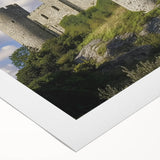 Rolled canvas artwork depicting a vibrant landscape with a majestic castle surrounded by lush greenery and a serene sky, ideal for home decor or art collectors.