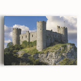 Stretched canvas artwork depicting a vibrant landscape with a majestic castle, lush greenery, and a clear blue sky, ideal for home decor.