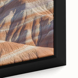 Close-up of a framed canvas print showcasing a vibrant landscape with dramatic cliffs and lush greenery, perfect for home decor and nature enthusiasts.