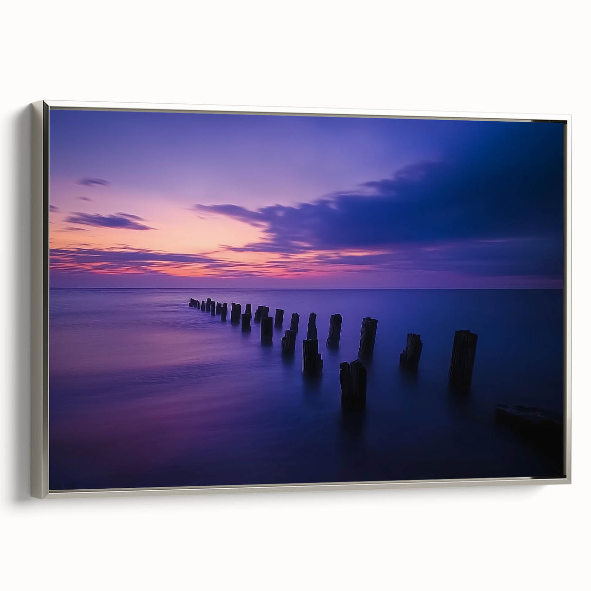 Framed canvas artwork depicting a serene beach landscape with vibrant colors and dynamic waves, presented in a sleek silver frame, ideal for home decor.