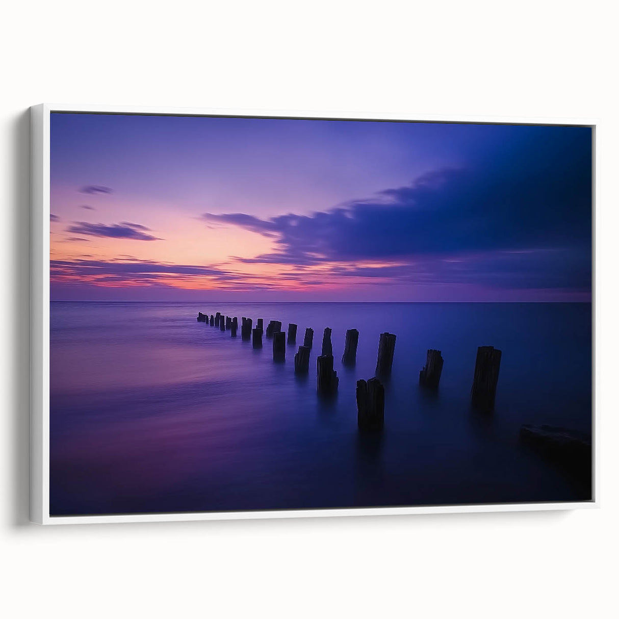 Framed landscape canvas art depicting serene beaches with soft waves and a clear sky, showcased from a white side view, perfect for coastal decor.