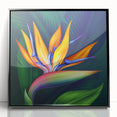 Framed wall art featuring a vibrant Bird of Paradise design with colorful floral elements, set in a sleek black frame, ideal for modern home decor accents.
