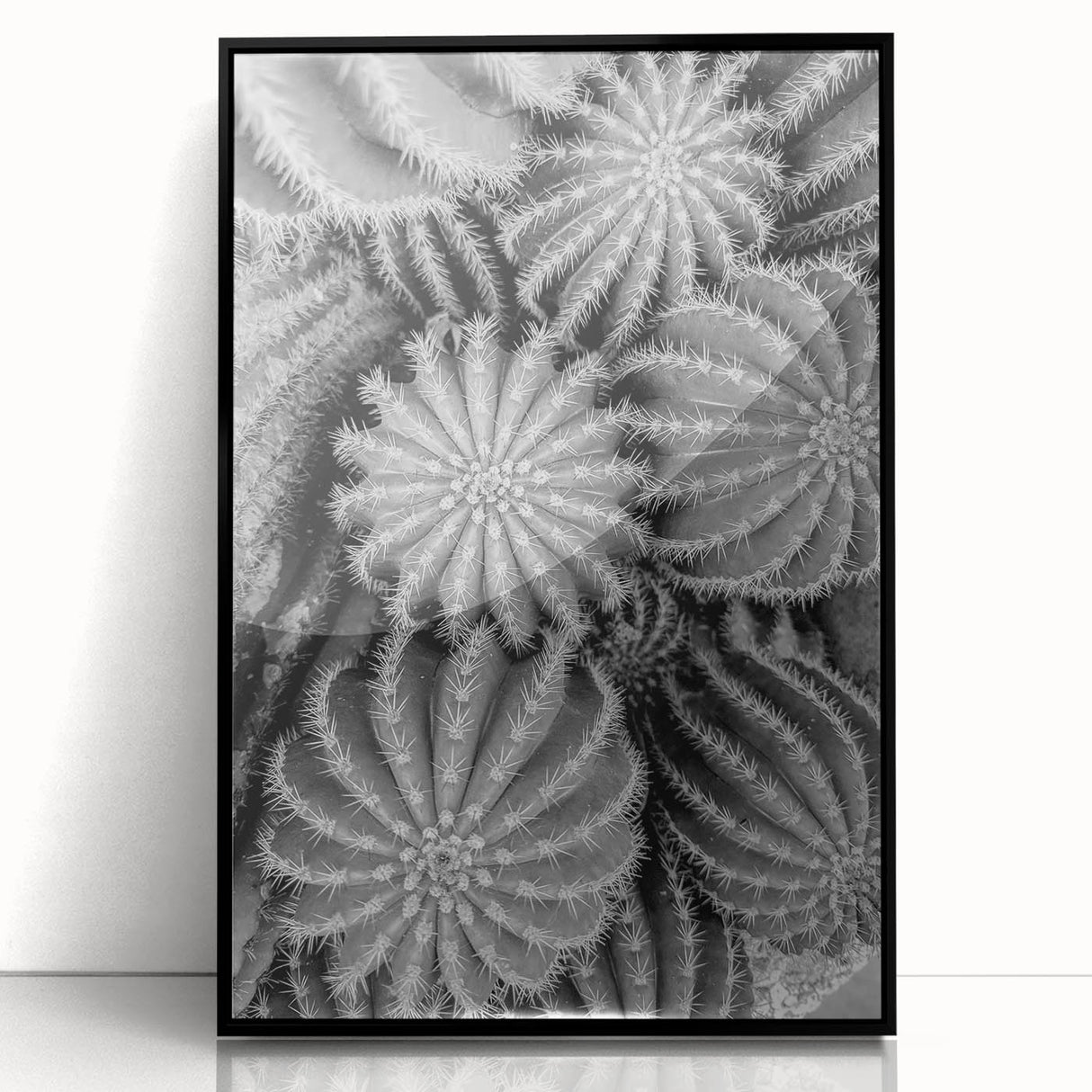 Framed wall art featuring a botanical design of cacti in vibrant green and earthy tones, displayed in a sleek black frame, perfect for modern decor.