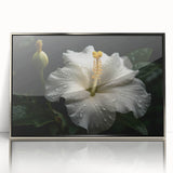 Framed botanical hibiscus wall art featuring vibrant pink and green colors set against a silver background, adding a touch of elegance to any decor.