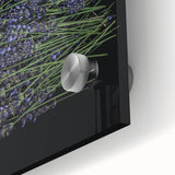 Close-up of a botanical wall art piece featuring delicate lavender flowers on a vibrant green background, displayed behind acrylic glass for a polished look. Perfect for adding a touch of nature-inspired elegance to home decor.