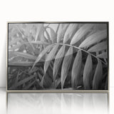 Framed acrylic wall art featuring a botanical design of vibrant flowers and leaves, elegantly displayed with a silver frame, perfect for home decor.