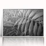 Framed wall art featuring a botanical leaves design in vibrant colors, displayed in a sleek white frame. Ideal for adding a touch of nature-inspired elegance to home decor.
