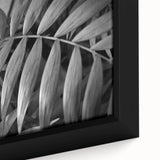 Close-up of a framed botanical wall art piece showcasing vibrant floral designs and intricate green leaves, perfect for home decor and nature enthusiasts.